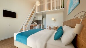 A bedroom with a bed, a desk, and a staircase leading to an upper level. - Larimar (Becici)