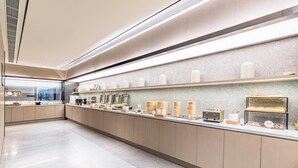 A modern kitchen with a long counter, various food containers, and appliances. - JI Hotel (Nanjing)
