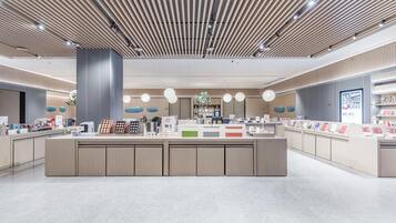 A modern, spacious lobby with a central reception desk, recessed lighting, and a polished tile floor.