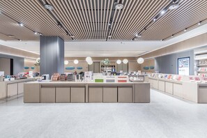 A modern, spacious lobby with a central reception desk, recessed lighting, and a polished tile floor. - JI Hotel (Nanjing)