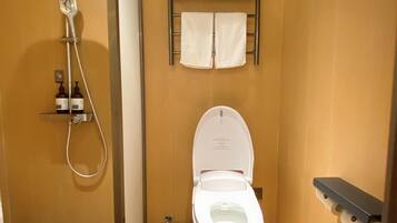 Un baño pequeño con ducha, inodoro y un cubo de basura.
