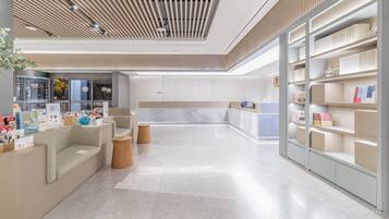 Un interior moderno con mostrador de recepción, zona de estar y estanterías.