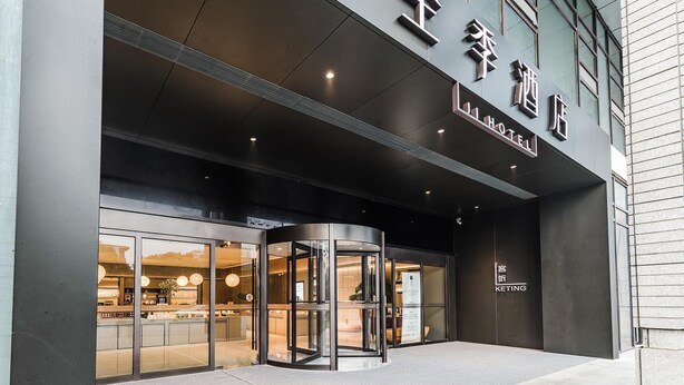 A hotel entrance with a revolving door, large glass windows, and a sign indicating the hotel name. - JI Hotel (Nanjing)