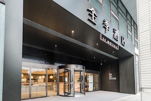 A hotel entrance with a revolving door, large glass windows, and a sign indicating the hotel name. - JI Hotel (Nanjing)