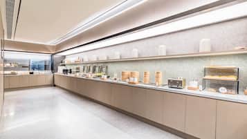 A modern kitchen with a long counter, various food containers, and appliances.