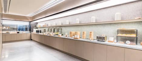 A modern kitchen with a long counter, various food containers, and appliances.