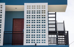 A building with a blue facade, a brown door, and a white lattice structure.