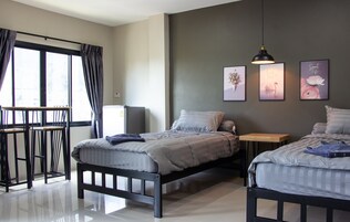 Un dormitorio moderno con dos camas, un escritorio y una silla.