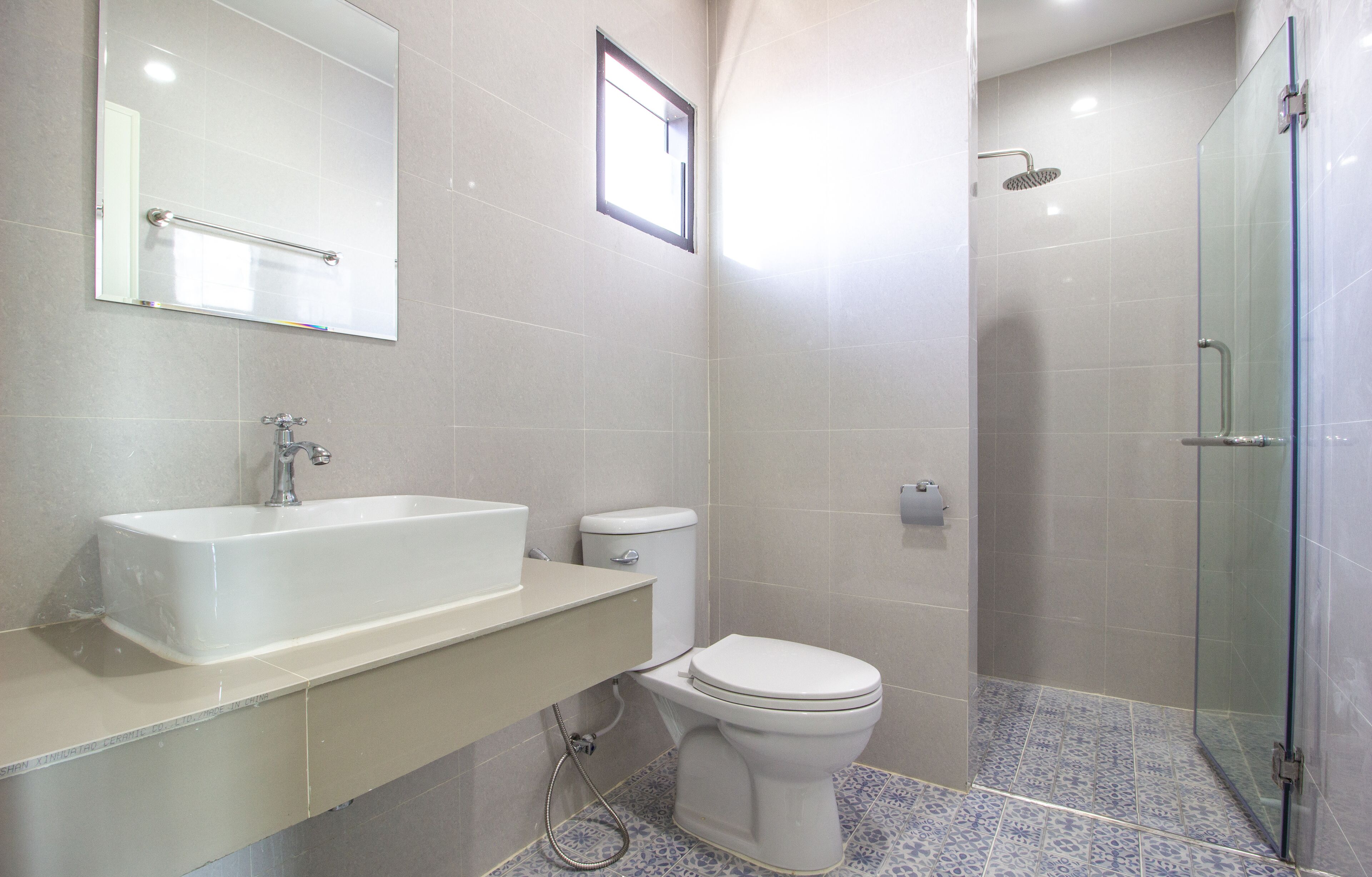 A bathroom with a large sink, toilet, and a glass-enclosed shower area.