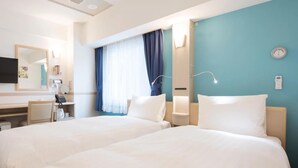 A hotel room with two beds, a desk with a telephone, a mirror, and a window with curtains. - Toyoko Inn Fujisan Otsuki-eki (Otsuki)