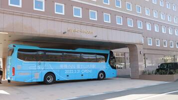 A blue bus parked in front of a building with the sign "toyoko-inn.com".