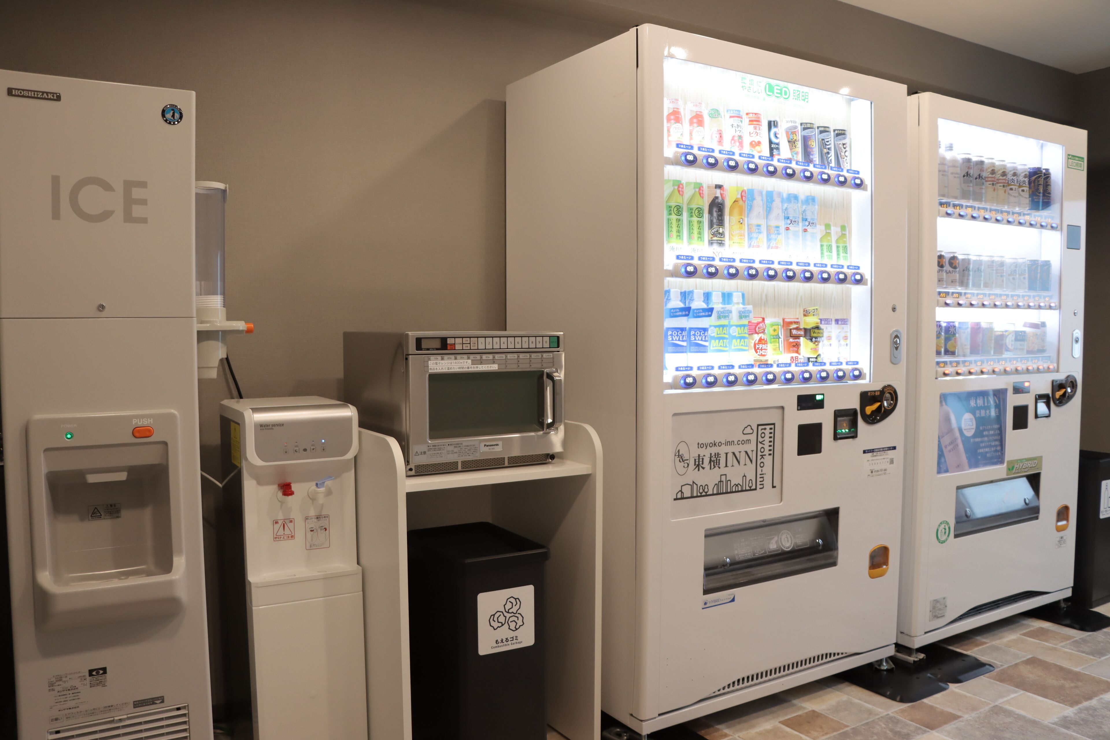 A vending machine with a water dispenser and a microwave, and a refrigerator labeled "ICE".