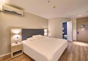 A hotel room with a bed, bedside table, nightstand, and an air conditioning unit. - Hanting Hotel (Zhengzhou)