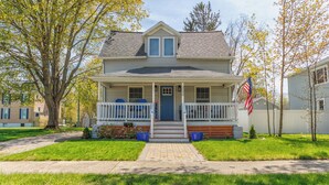 A two-story house with a front porch, a mailbox, and an American flag. - A Liberty Haven - 2 blocks from South Beach, (South Haven)