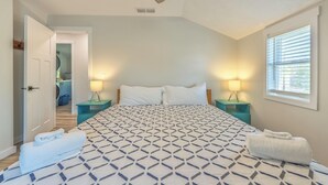 A bedroom with a bed, two bedside tables with lamps, a ceiling fan, and a window with blinds. - A Liberty Haven - 2 blocks from South Beach, (South Haven)