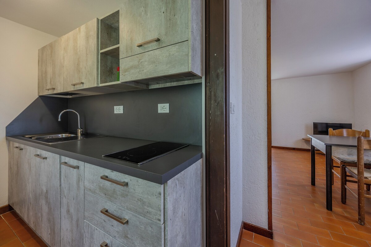 Une cuisine avec des meubles de rangement en bois, un évier et une cuisinière.