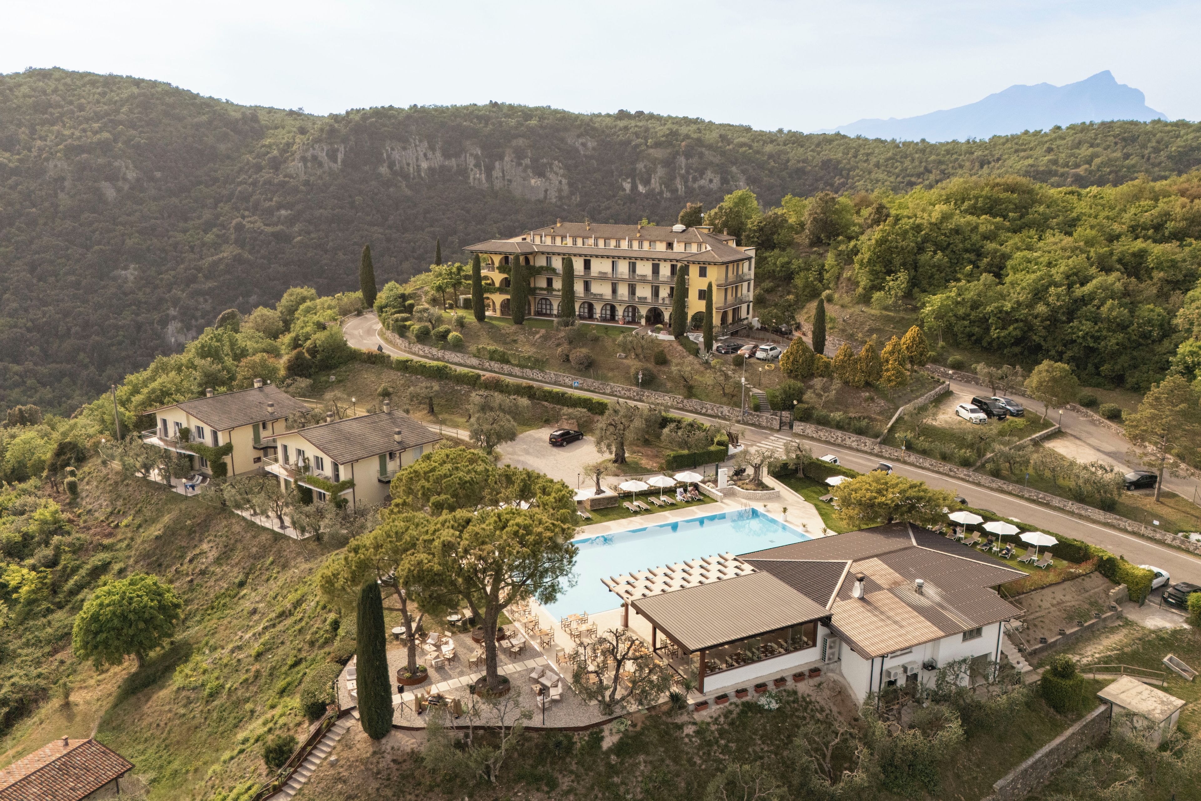 Um grande hotel com vários edifícios, piscina e paisagem montanhosa deslumbrante.