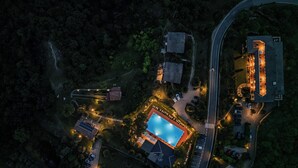 Luchtbeeld van een resort met een zwembad, meerdere gebouwen en een parkeerplaats.