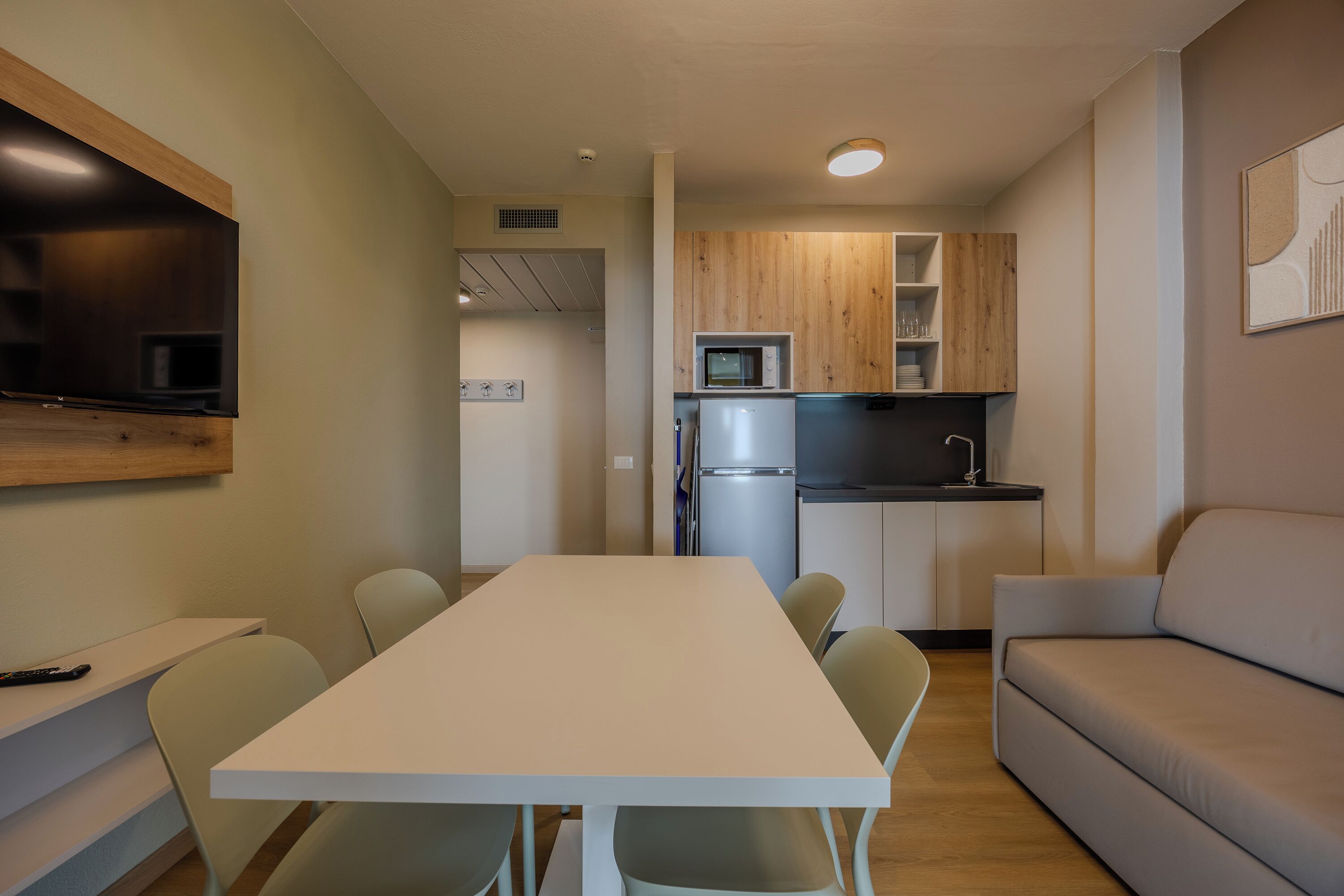 A compact living space with a kitchenette, a dining area, and a sofa.