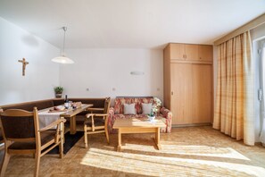 Un salon comprenant une table à manger en bois, des chaises, un canapé et un meuble en bois.