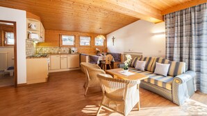 Un interior acogedor de madera con comedor, sofá y cocina.