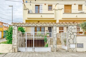 A two-story building with a stone facade, a gated entrance, and a small balcony. - Holiday Home "Ampuriabrava" with Wi-Fi & A/C (Castello d'Empuries)
