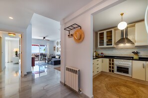 Una cocina moderna con horno empotrado, lámpara colgante y radiador.