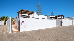 A modern building with a white exterior, a wooden pergola, and a staircase leading to the entrance. - Villa 'Princesa Faina' with Partial Sea Views, Private Pool and Wi-Fi (Tias)