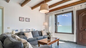 A living room with a sofa, a coffee table, and a large window with curtains. - Villa 'Princesa Faina' with Partial Sea Views, Private Pool and Wi-Fi (Tias)
