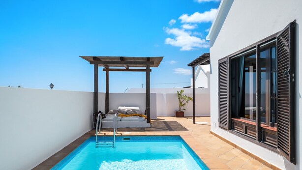 A swimming pool with a pergola, a bed with pillows, and a potted plant. - Villa 'Princesa Faina' with Partial Sea Views, Private Pool and Wi-Fi (Tias)