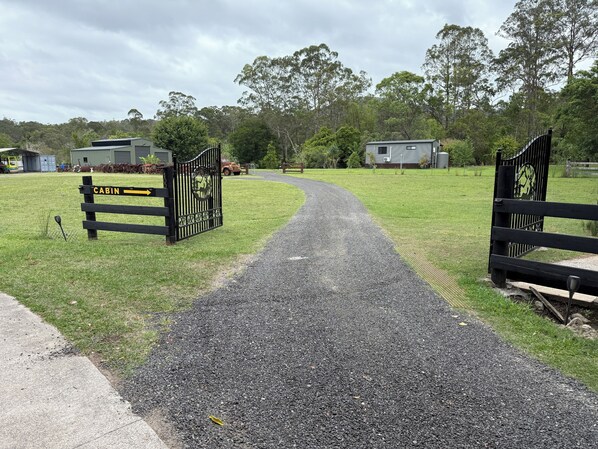 A gravel path leading to a cabin with a black gate. - Country cabin (Landsborough)