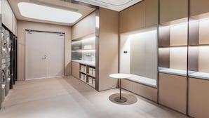 A modern hotel corridor with a built-in washer and dryer, a round table, and a large window.