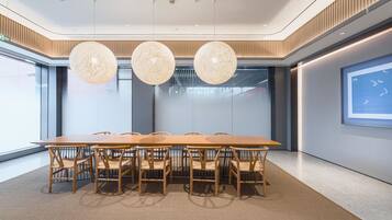 A modern conference room with a long table, six chairs, and three spherical pendant lights.