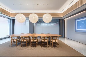 A modern conference room with a long table, six chairs, and three spherical pendant lights.