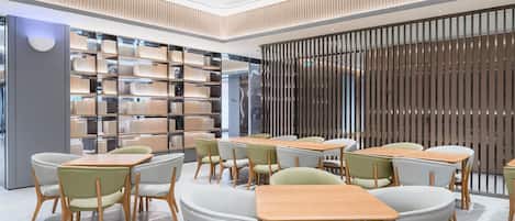 A modern interior with a central seating area, a bookshelf, and a partition wall.