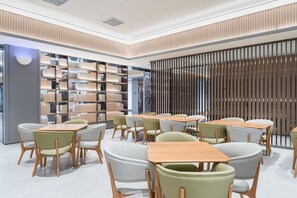A modern interior with a central seating area, a bookshelf, and a partition wall.