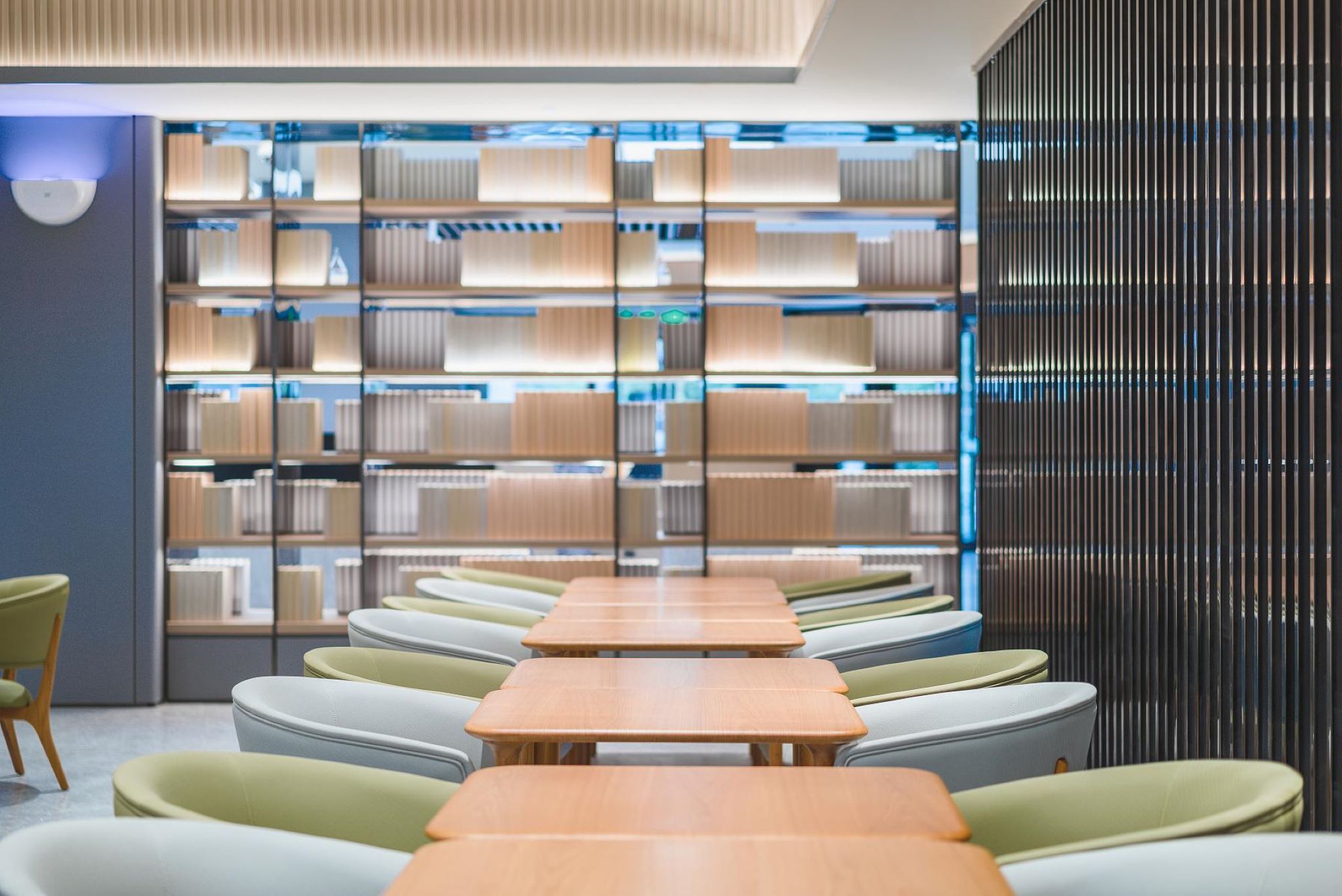 Una biblioteca moderna con estanterías, zonas de descanso y un diseño contemporáneo.