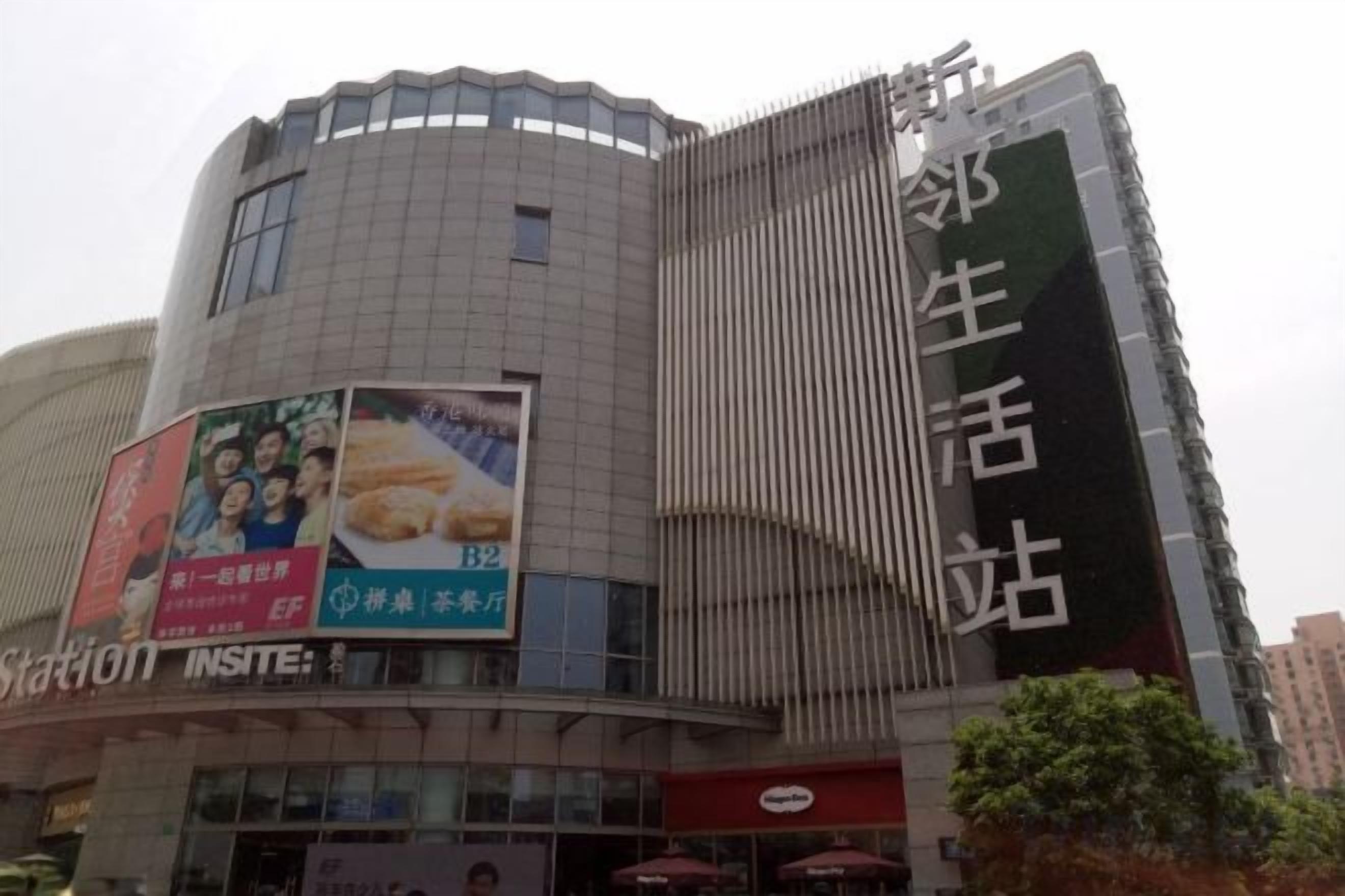 A multi-story commercial building with a prominent advertisement on the left side.