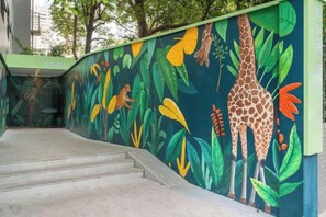 A staircase with a mural of a giraffe and foliage.