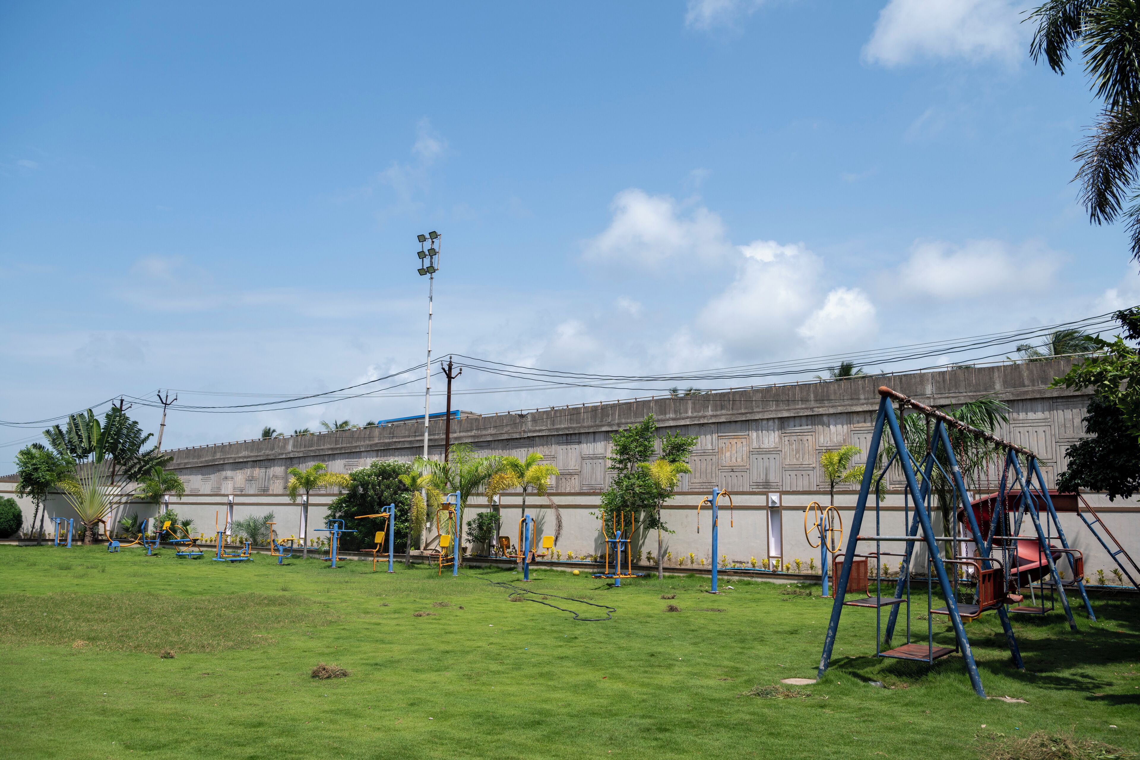 An outdoor playground with various exercise equipment and a swing set.