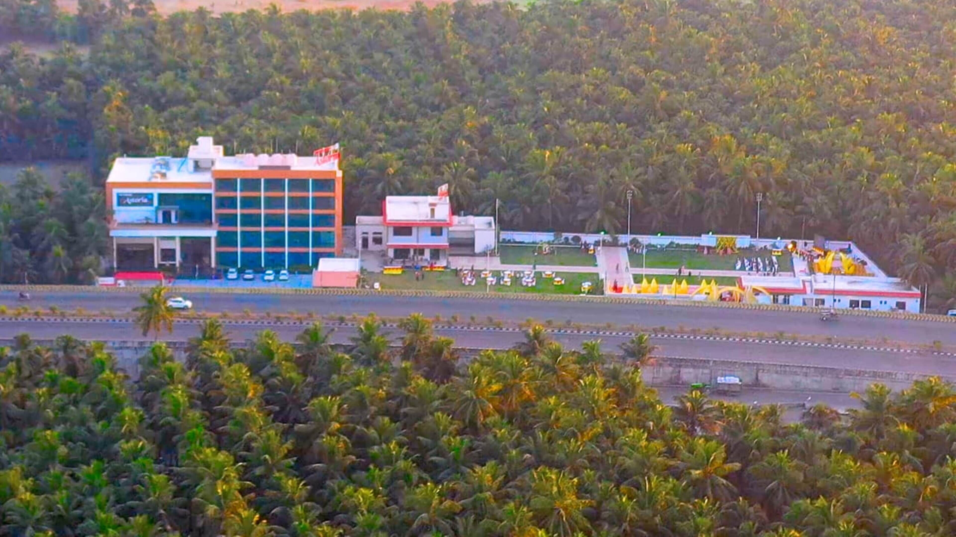 A building with multiple floors, a parking lot, and a road in the foreground.