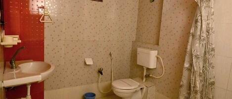 A small bathroom with a sink, toilet, and shower curtain.