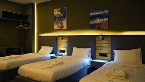A hotel room with two beds, a desk, and a microwave. - Aitch Boutique Hotel - an LIH Hotel (Madaba)
