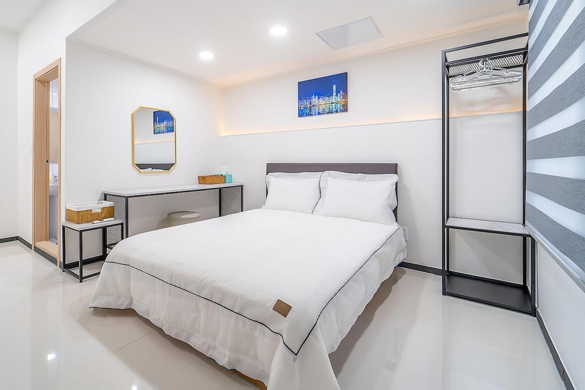 Une chambre d’hôtel moderne équipée d’un grand lit, d’un bureau, d’une chaise et d’une armoire.