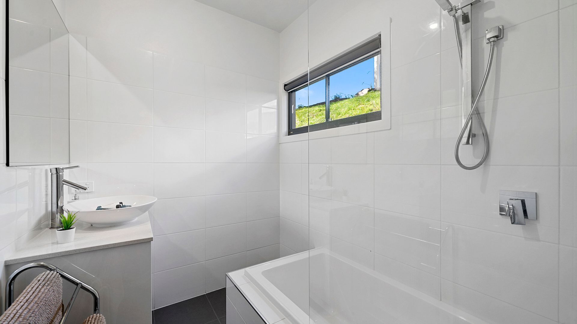 Un baño moderno con lavamanos blanco, bañera y ducha.