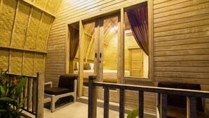 A wooden interior with a balcony, a bed, and a window with curtains. - Puri Sadewa Balangan (Jimbaran)