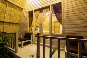 A wooden interior with a balcony, a bed, and a window with curtains. - Puri Sadewa Balangan (Jimbaran)
