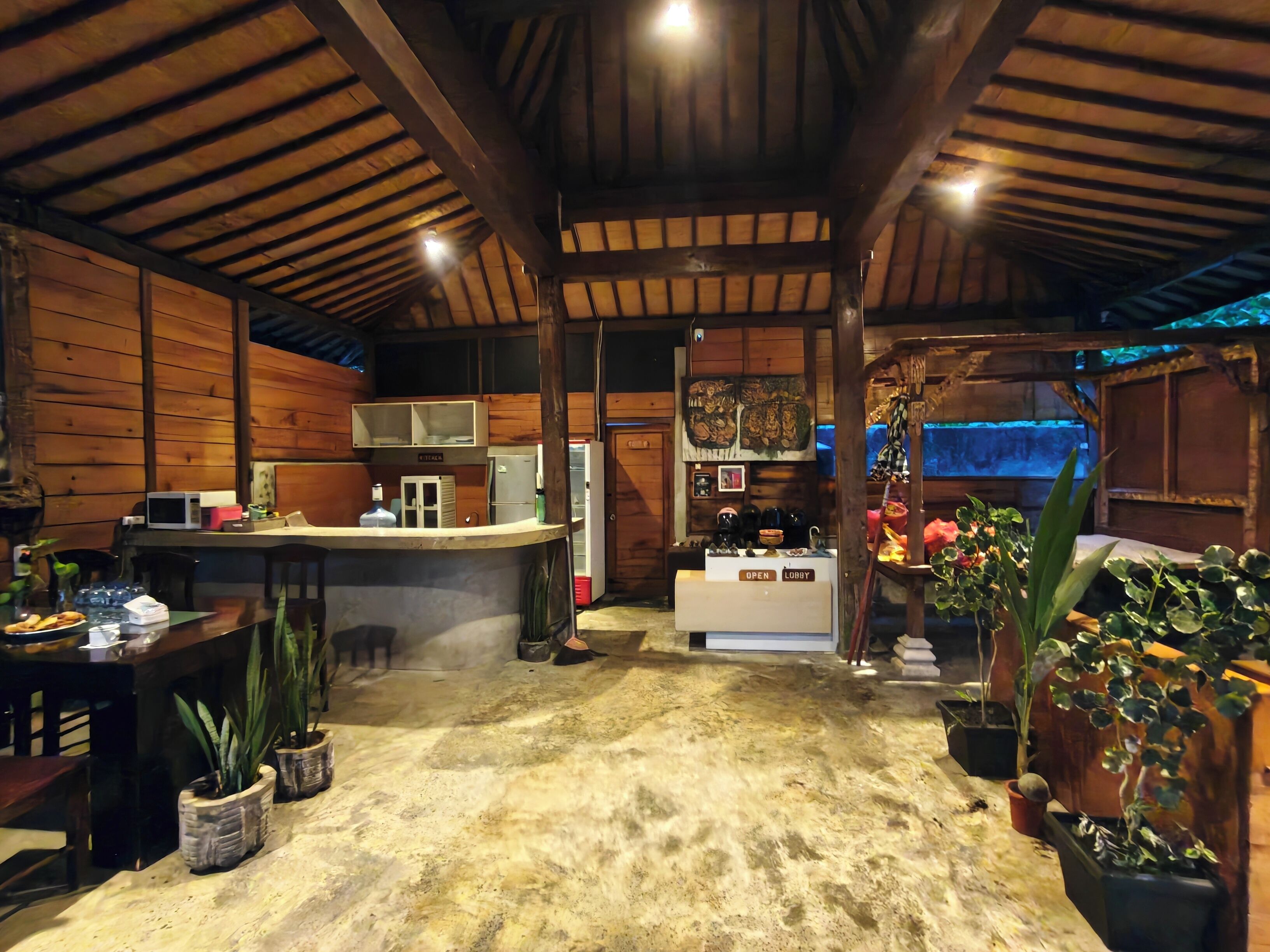 Un interior rústico con paredes de madera, una zona de cocina y una barra.