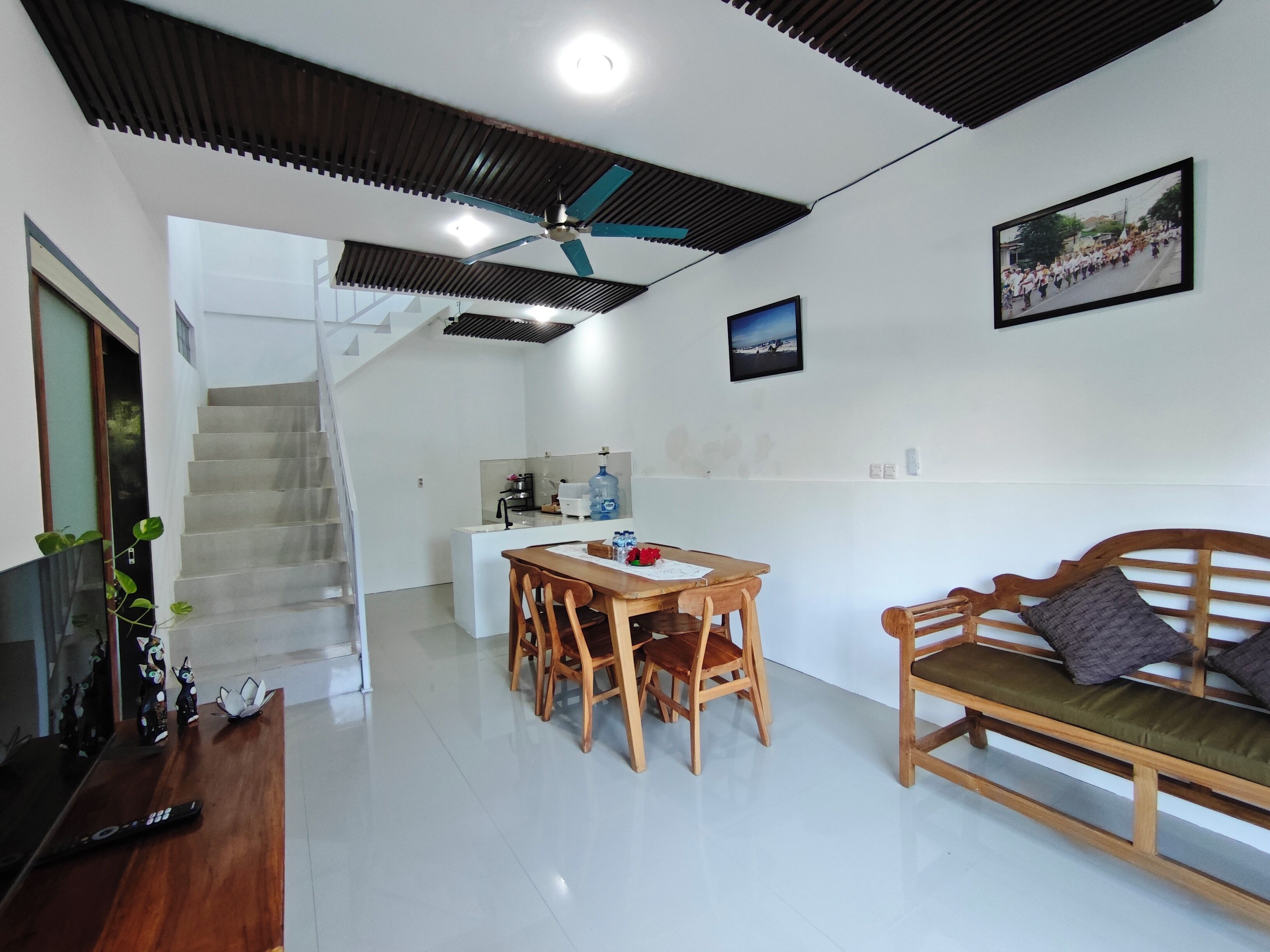Un interior moderno con comedor, sofá, escalera y cocina.