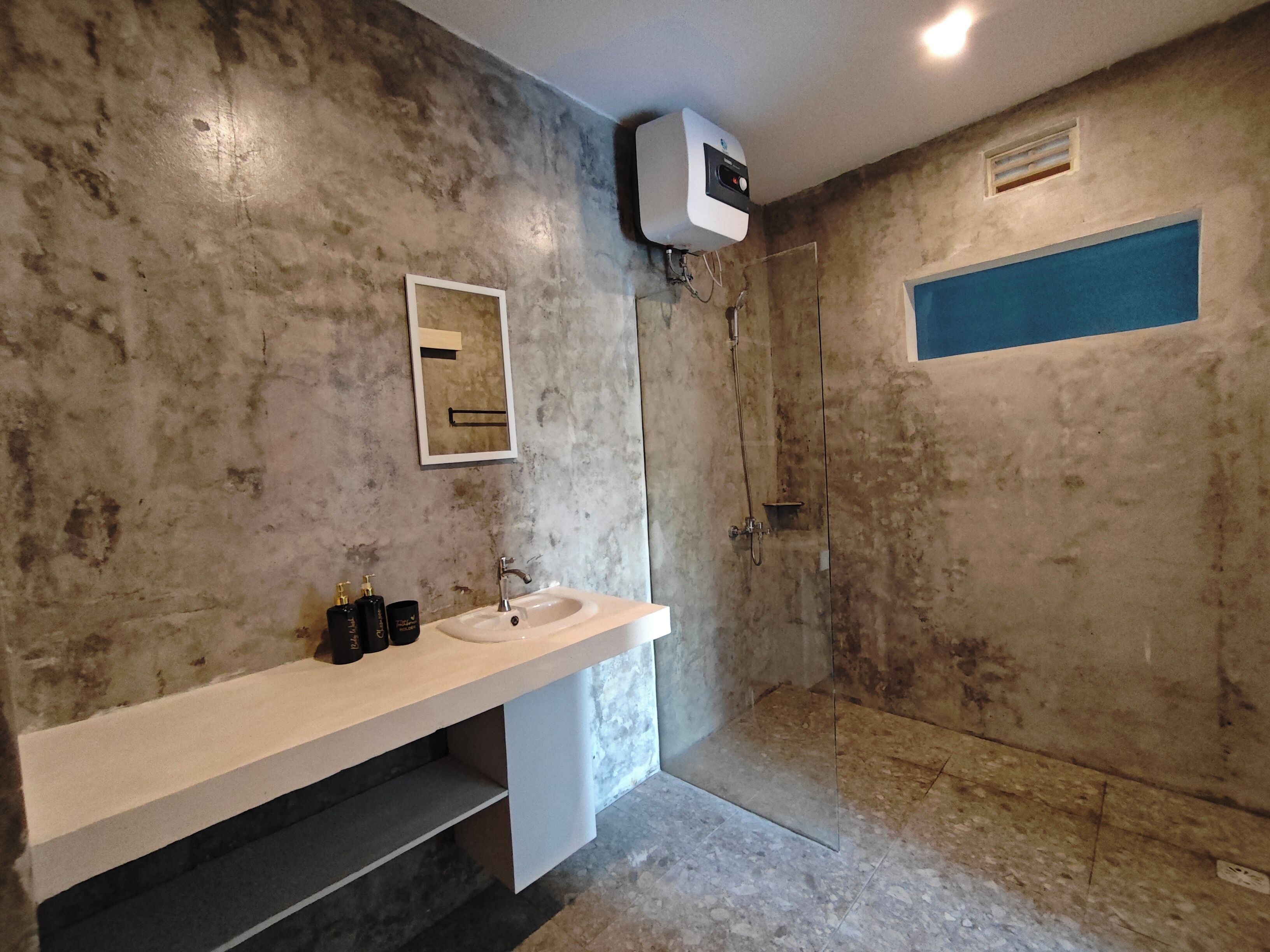 A bathroom with a white sink, mirror, and a shower area.